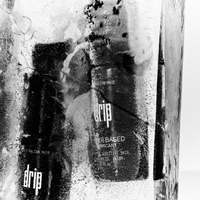 Black bottle labeled 'drip water based lubricant' with a textured background