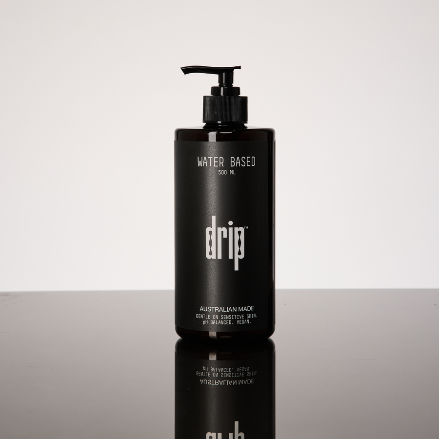 Black bottle labeled 'drip' on a reflective surface with a light gray background. drip water based lube.